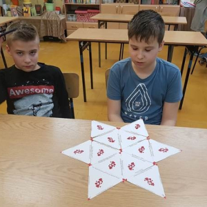 Szymon i Maciek ułożyli gwiazdę z trójkątów dopasowując pary mini dialogów. Na rogach gwiazdy powstało hasło.